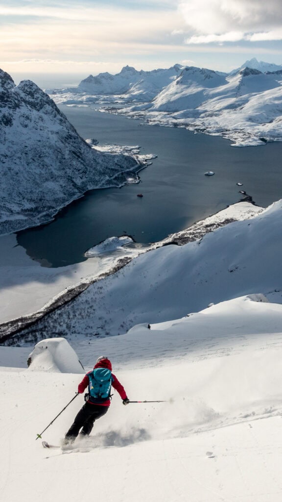 Skiers in powder snow above the fjord in Norway